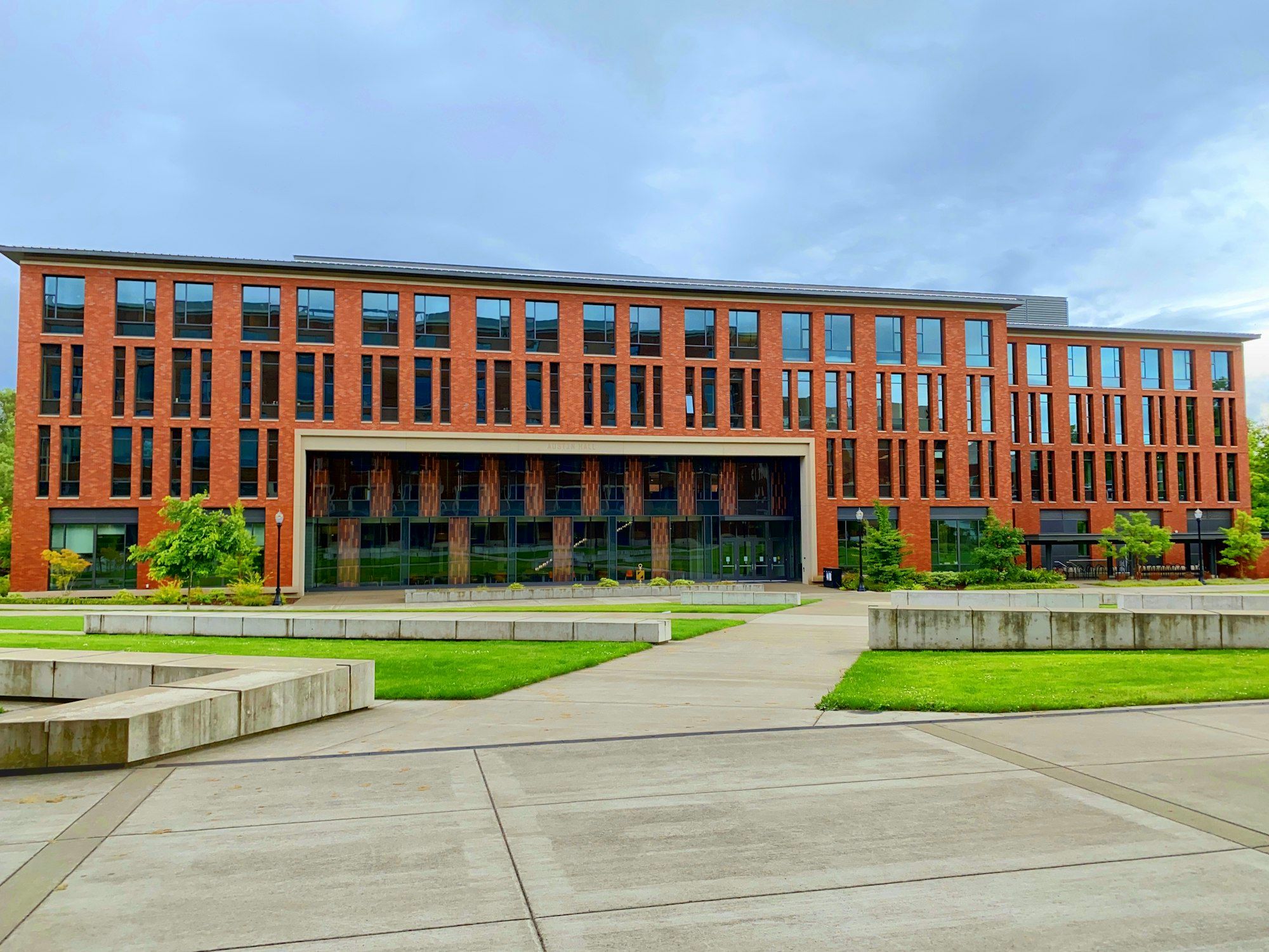 Red-brick university academic building facing a landscaped plaza