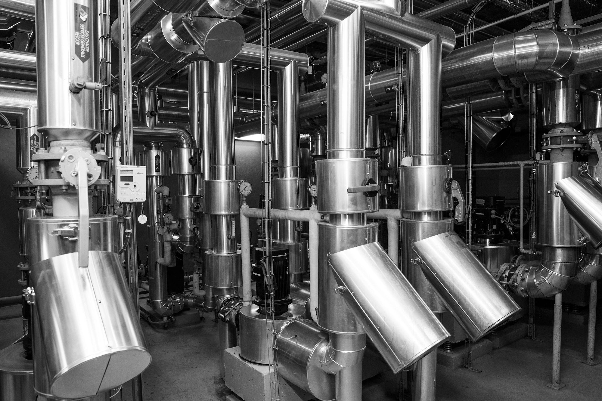 Mechanical room with insulated hot-water piping, valves and circulation pumps